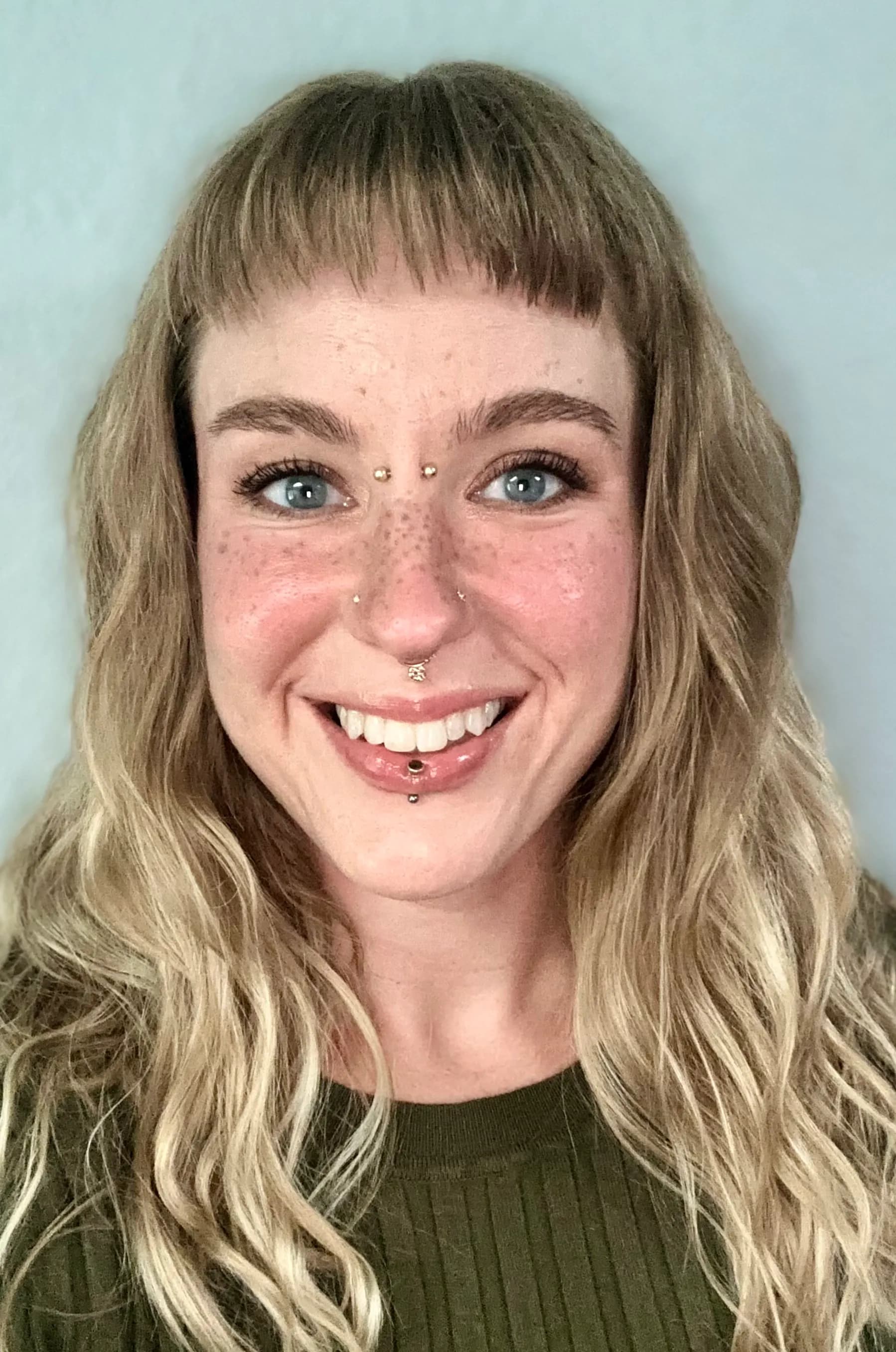 Emily Moorhead smiling against a gray office background.