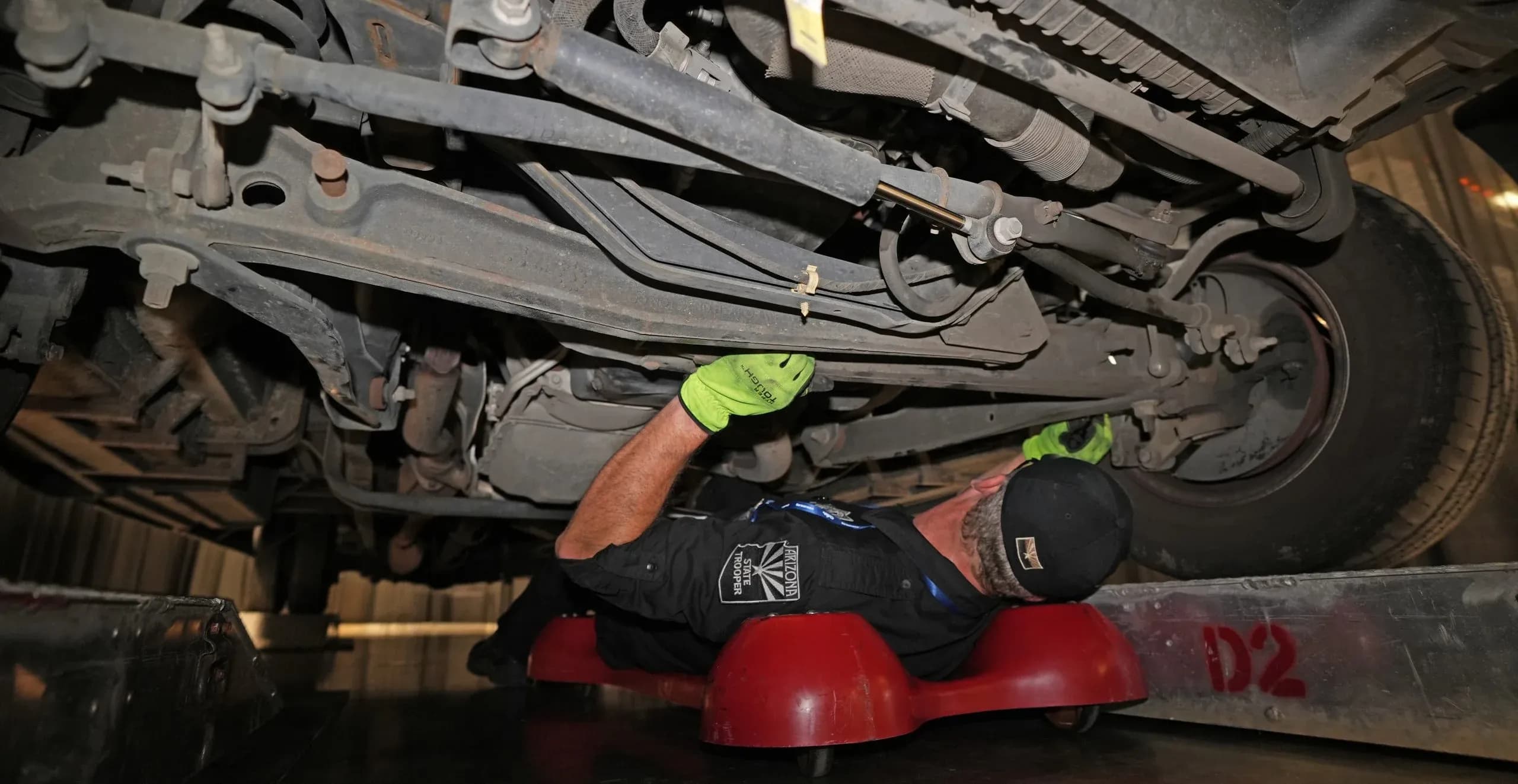 a member of the Arizona state trooper inspecting the underside of a truck